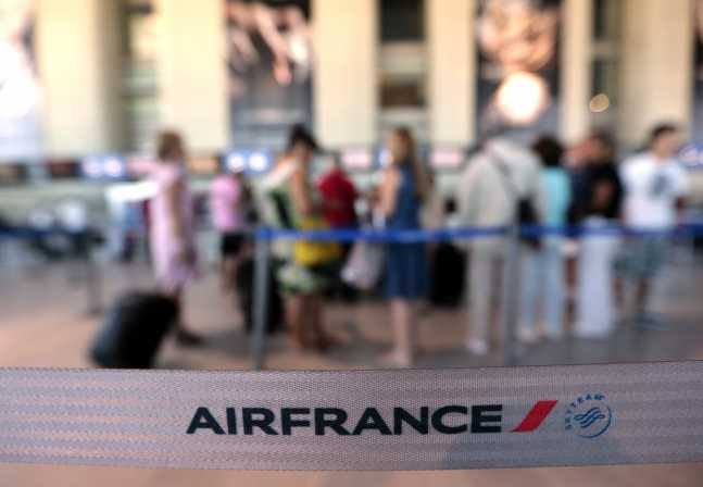 Passengers check-in at an Air France counter in Nice International airport in Nice